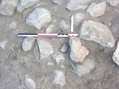 Τομέας 7: χάλκινη λεπίδα μαχαιριού όπως βρέθηκε μέσα σε γέμισμα της Ύστερης Εποχής Χαλκού (ανασκαφή 2008).