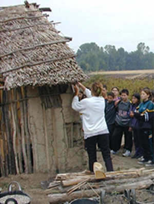 Neolithic construction techniques explained to schoolchildren visiting the site.