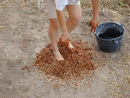 Preparation of building clay mixture for a construction experiment.